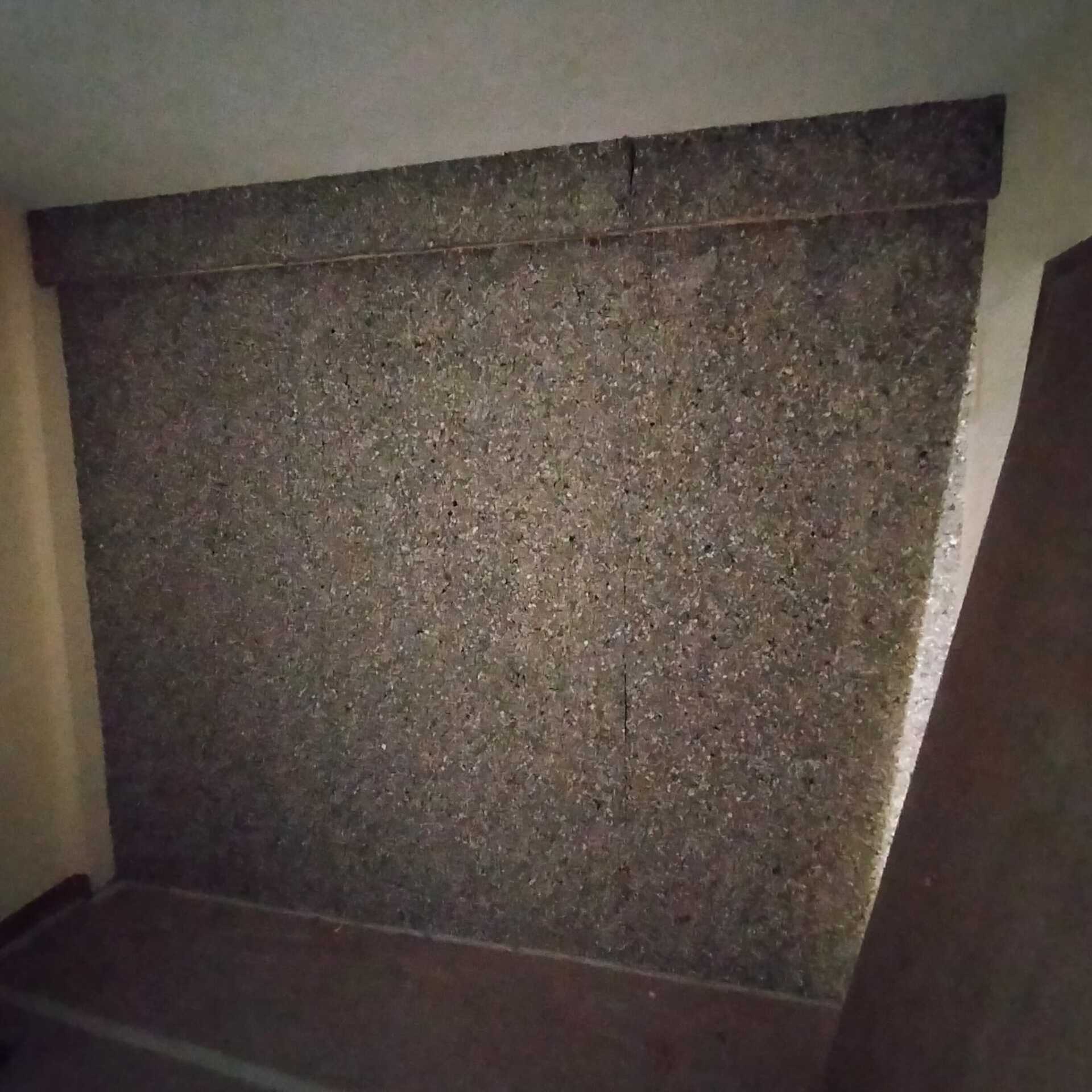 Una pared con muchas piedras pequeñas en una habitación.