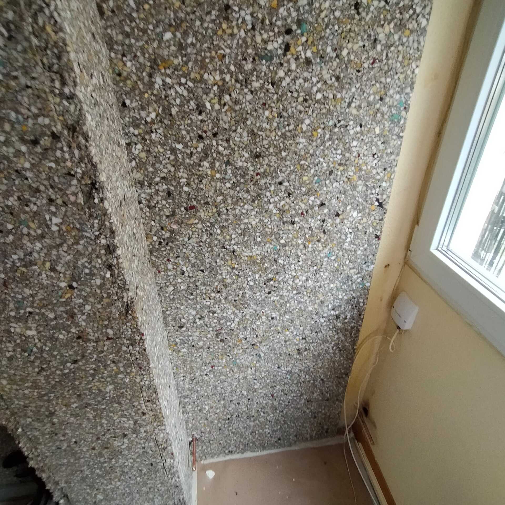 Una habitación con una pared de hormigón y una ventana