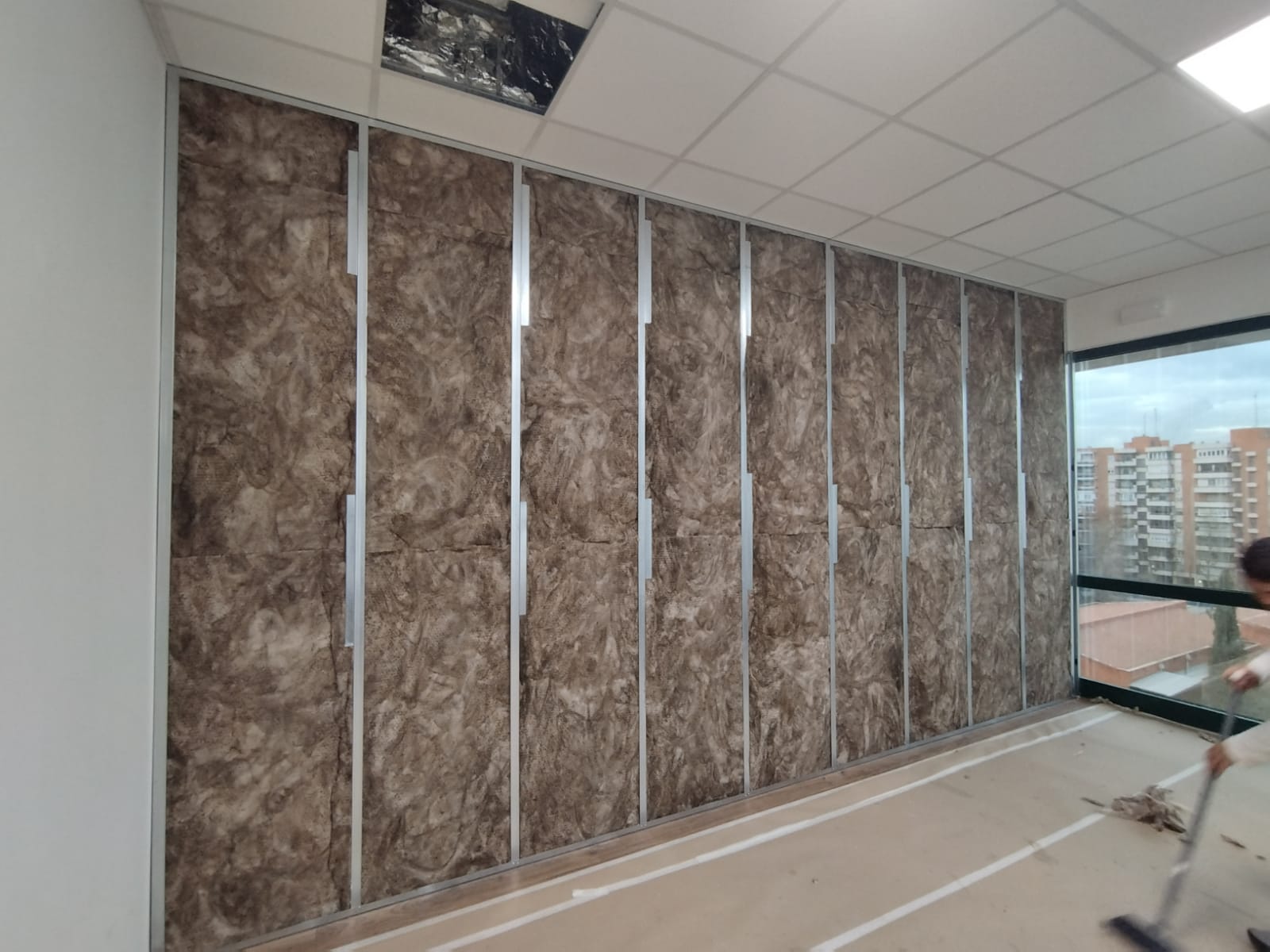 Un hombre está trabajando en una pared con aislamiento.