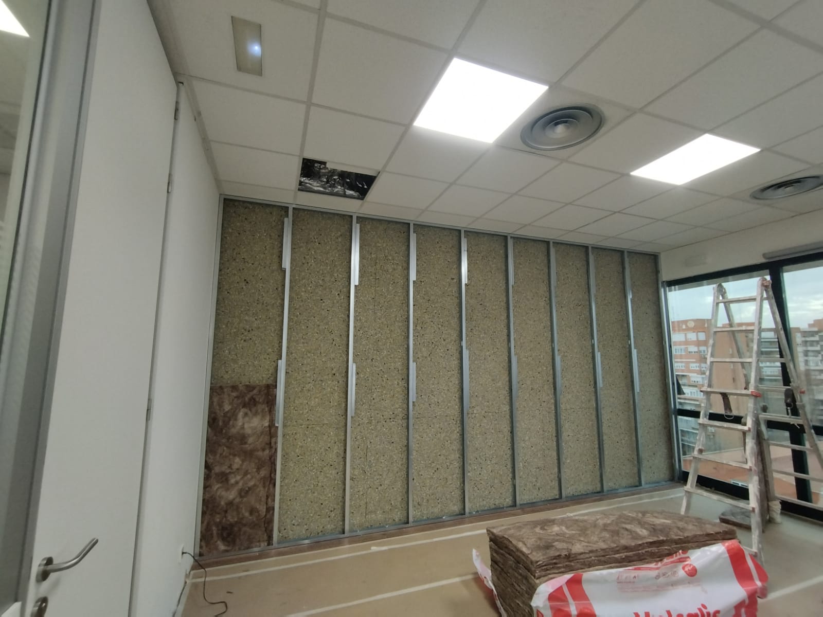 Una habitación con escalera y una bolsa aislante en el suelo.