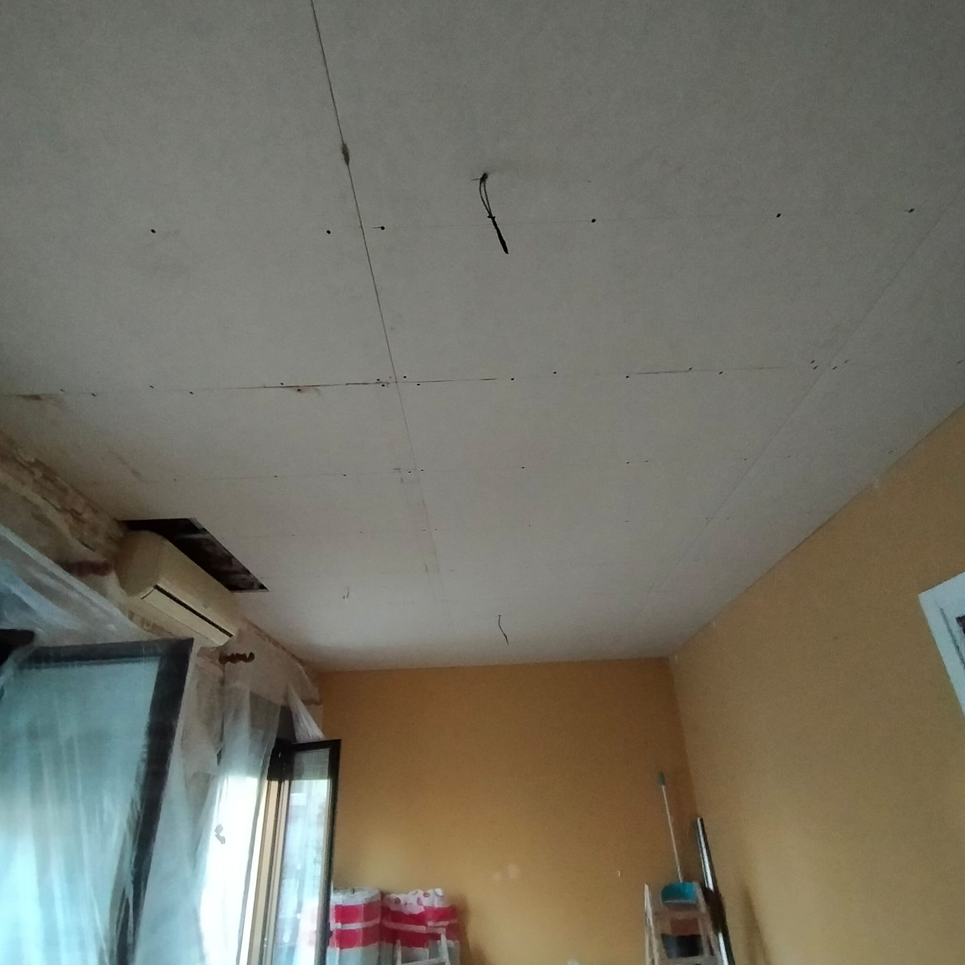 Una habitación con paredes amarillas y un techo blanco