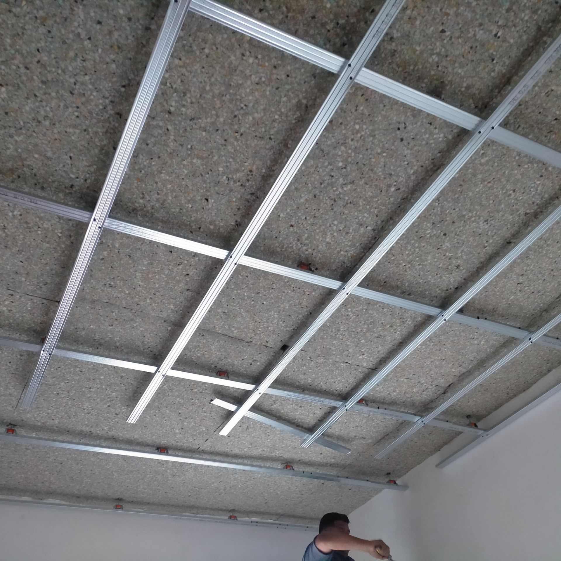 Un hombre está trabajando en el techo de una habitación