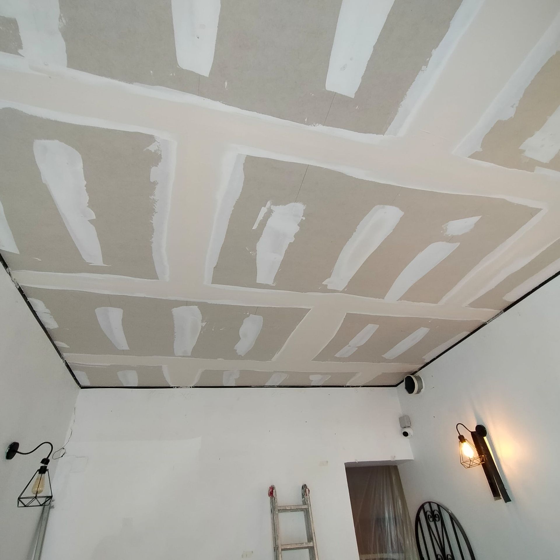 Una habitación con una escalera y una luz en la pared