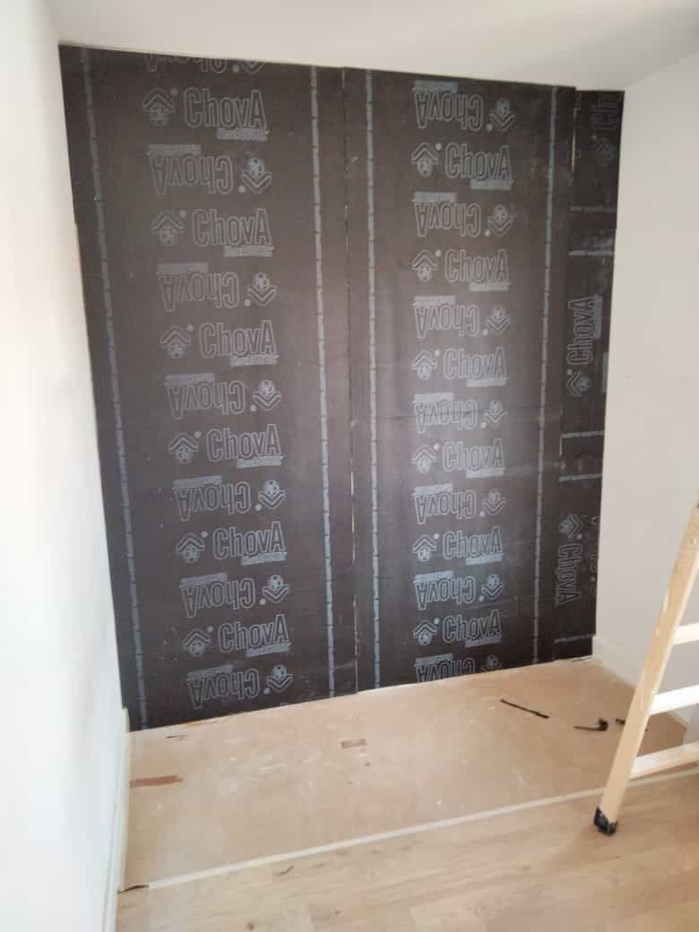 Una habitación con una escalera y una pizarra en la pared.