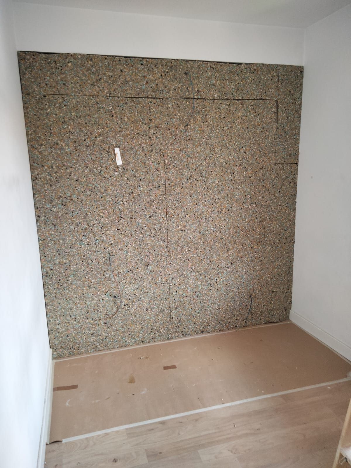 Una habitación con una pared recubierta de espuma y piso de madera.