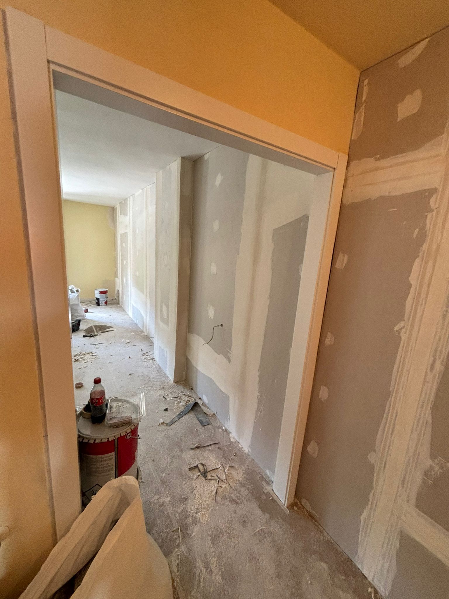 Un pasillo de una casa que está siendo pintada.