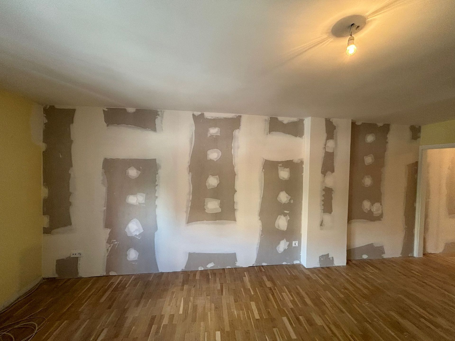 Una habitación vacía con suelo de madera y una luz en el techo.