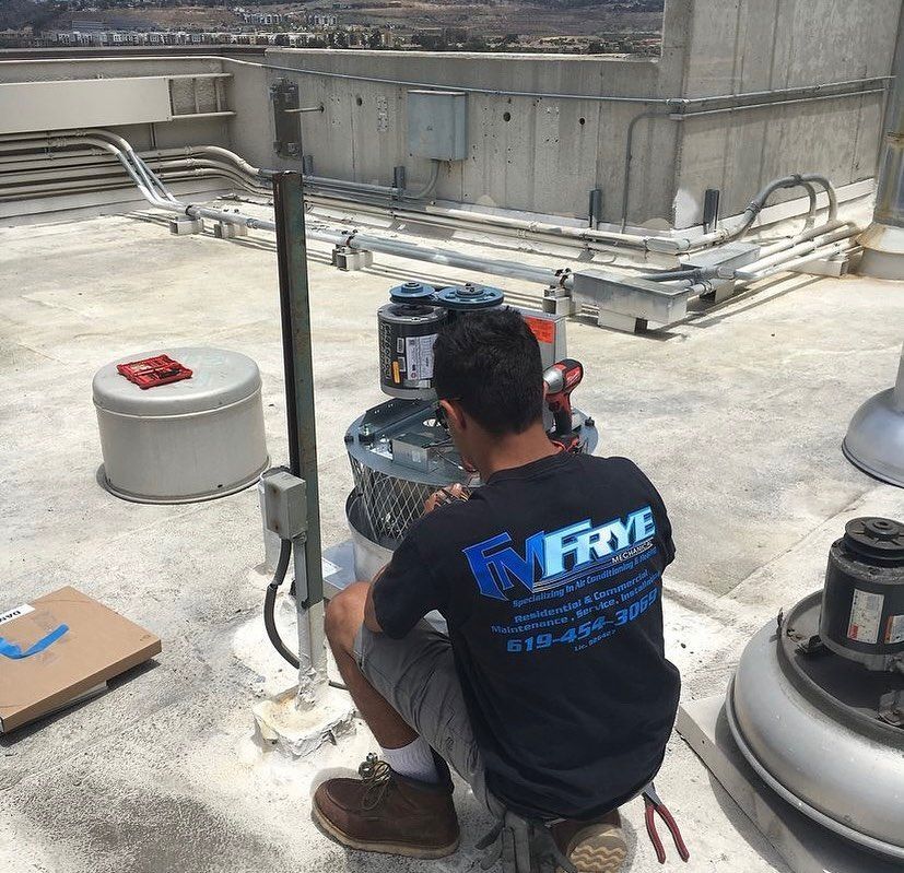 A man wearing a frye shirt is working on a roof