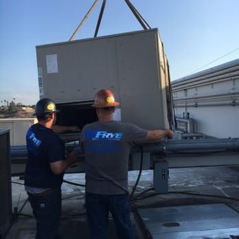 A man wearing a five shirt is working on a machine