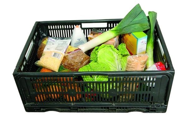 A person is opening a can of food in front of a box of food.