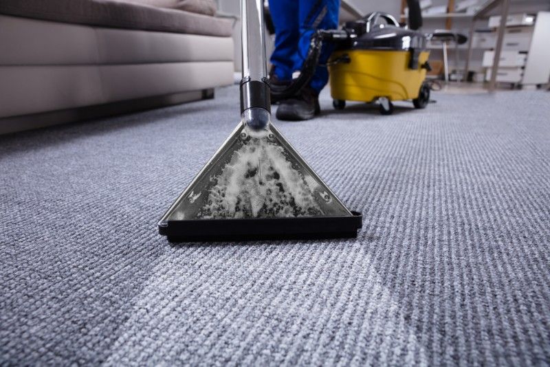 Person Vacuuming Light Blue Carpet With a Cleaning Machine — Mo Property Cleaning in Woden, ACT