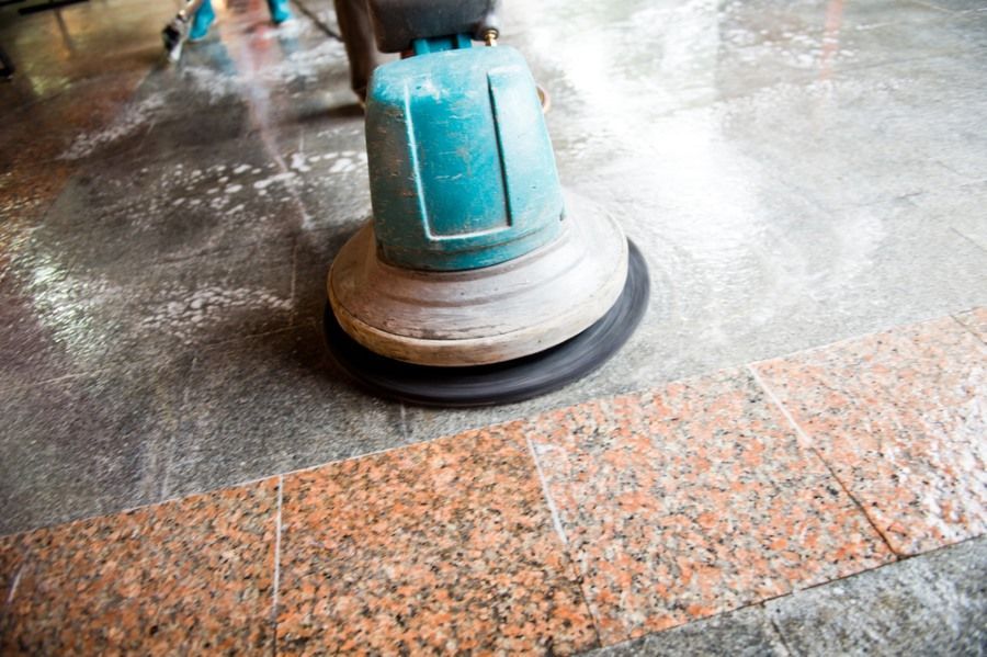 A Floor Cleaning Machine is Buffing a Granite Floor, Creating a Wet Shine— Mo Property Cleaning in Wright, ACT