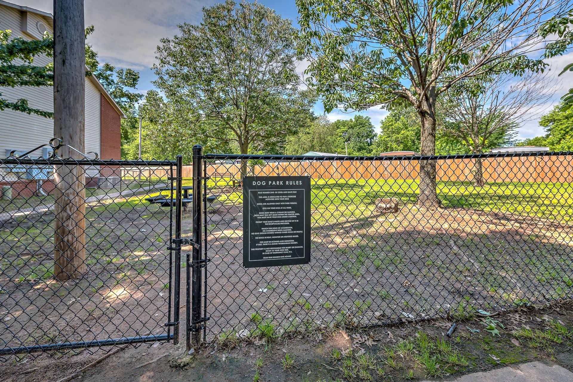 A chain link fence with a sign in front of it.