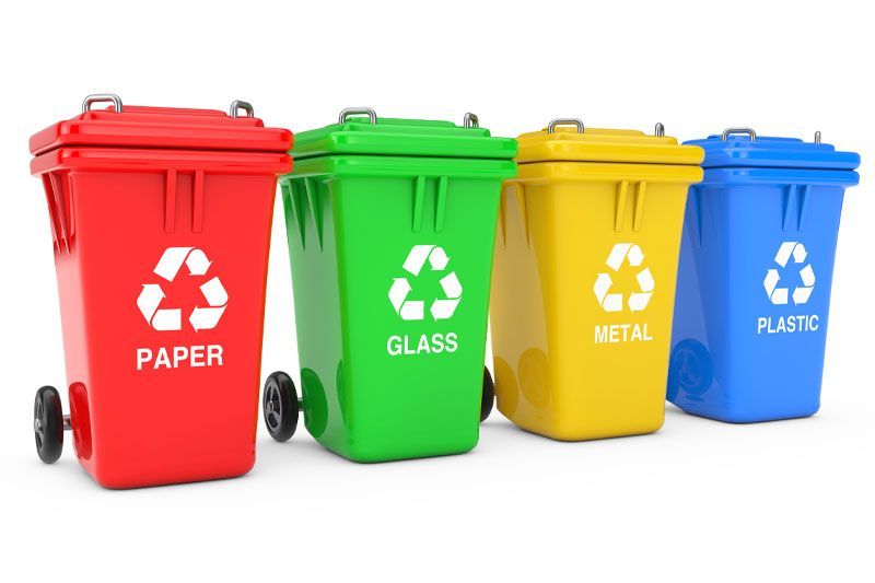 Four recycling bins are lined up in a row.