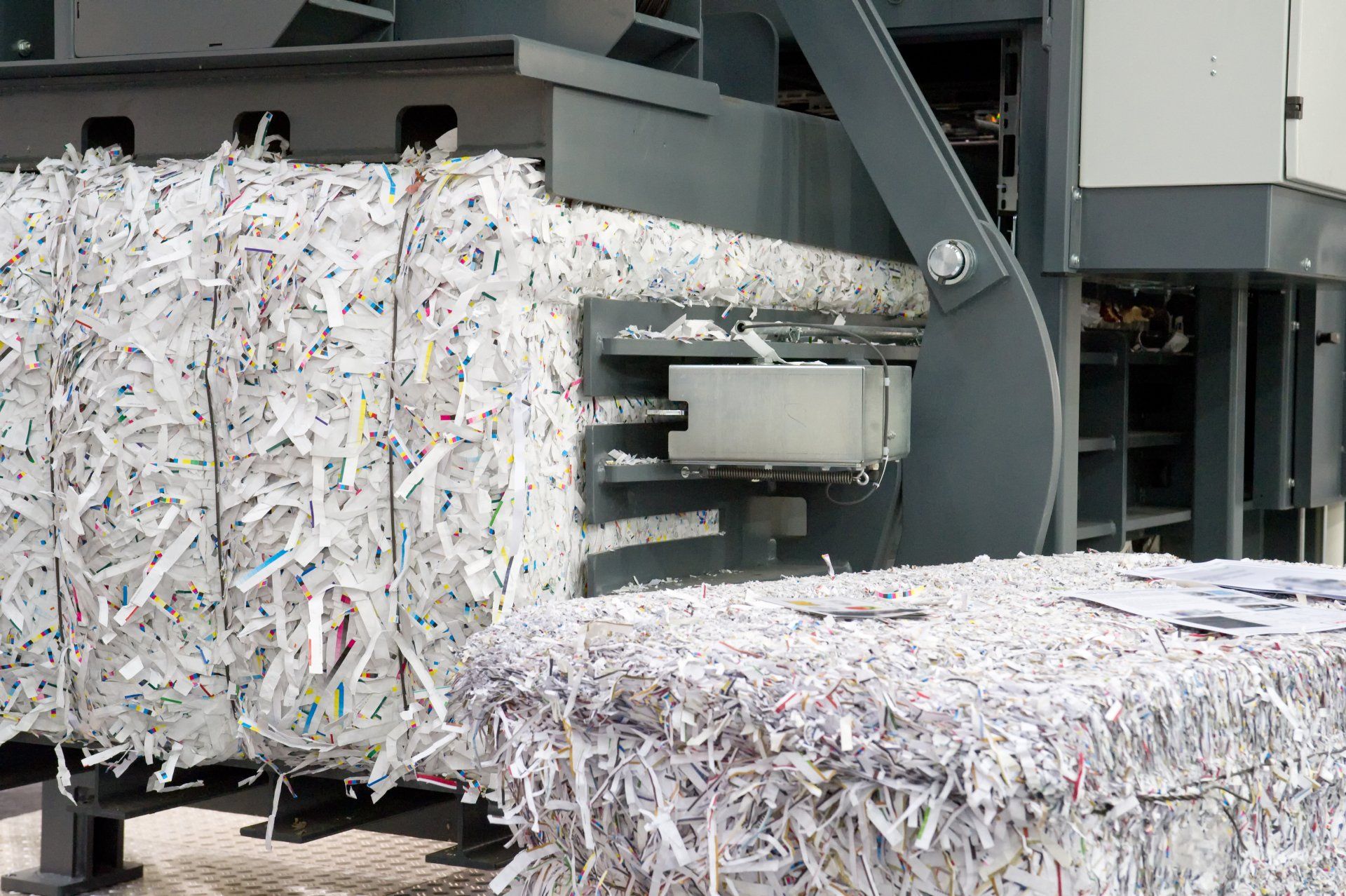 A pile of shredded paper is being processed in a machine.