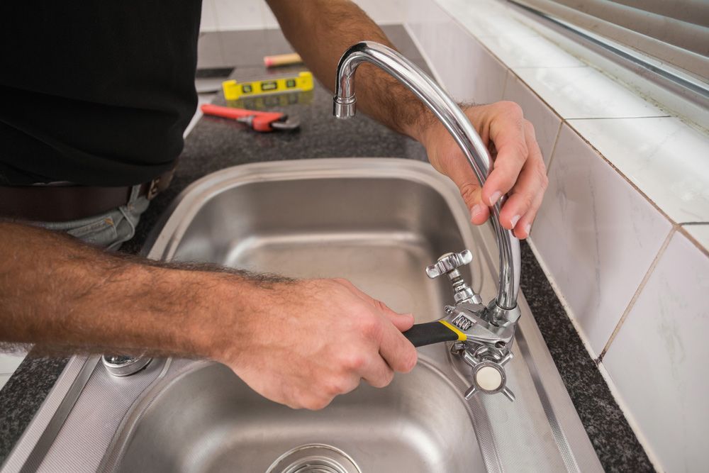Plumber Fixing Leaking Tap — Plumbing In Gulliver, QLD