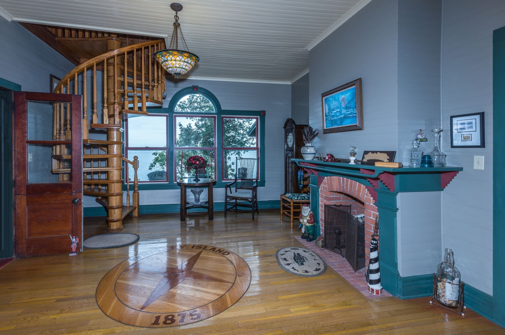 A living room with a spiral staircase and a fireplace.