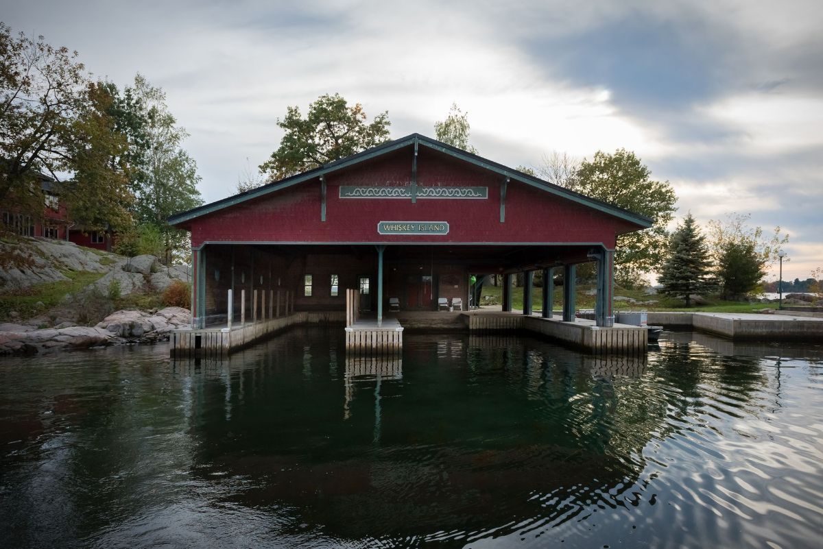A red building is sitting in the middle of a body of water.