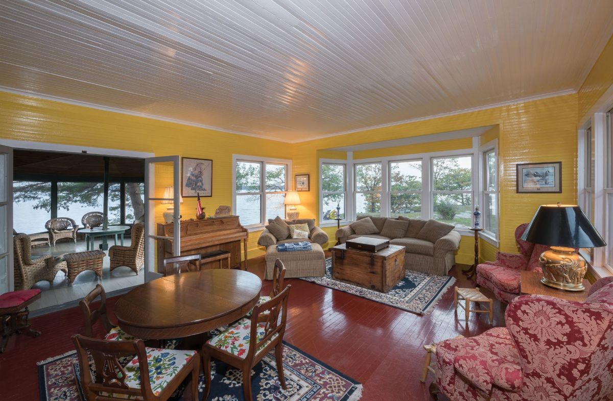 A living room with a couch , table , chairs and a piano.