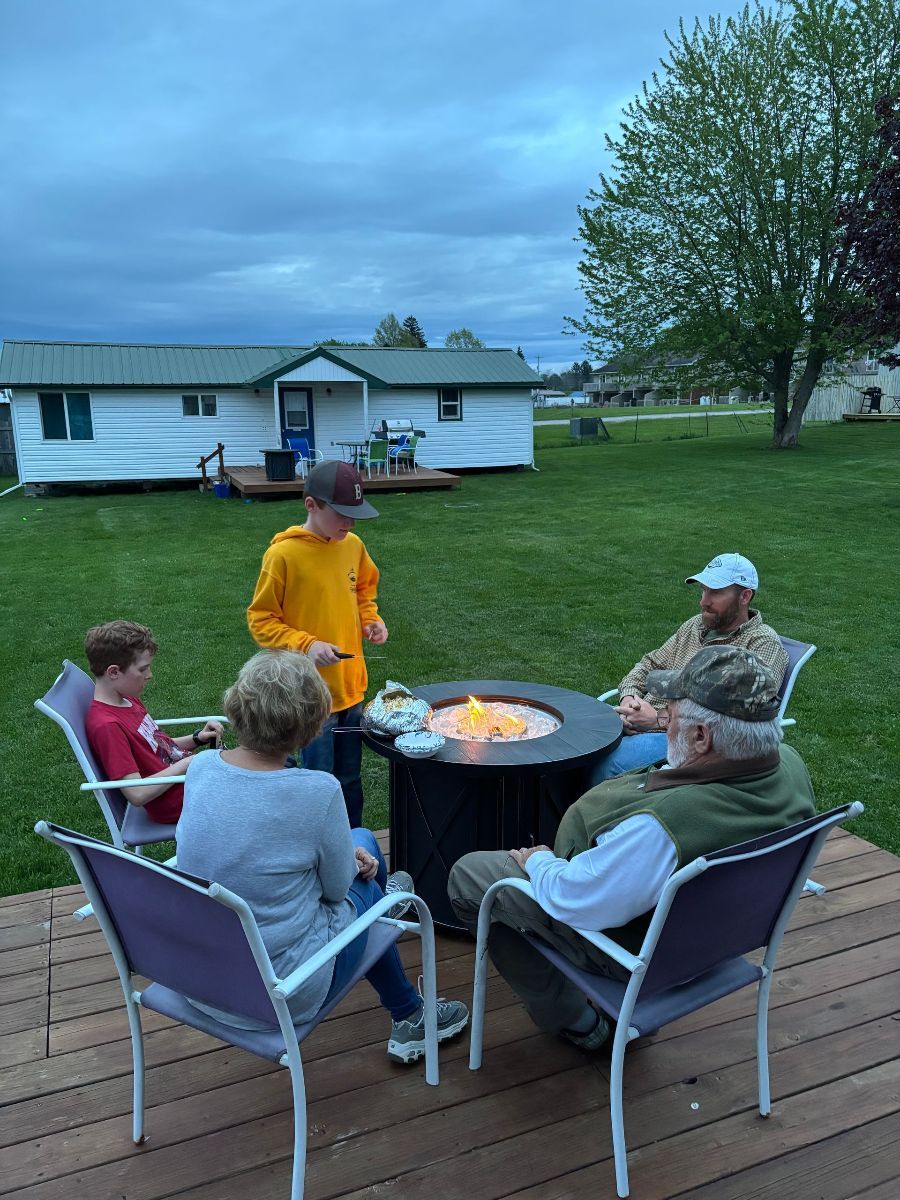 A bedroom with a bed , nightstand , lamp and painting on the wall.