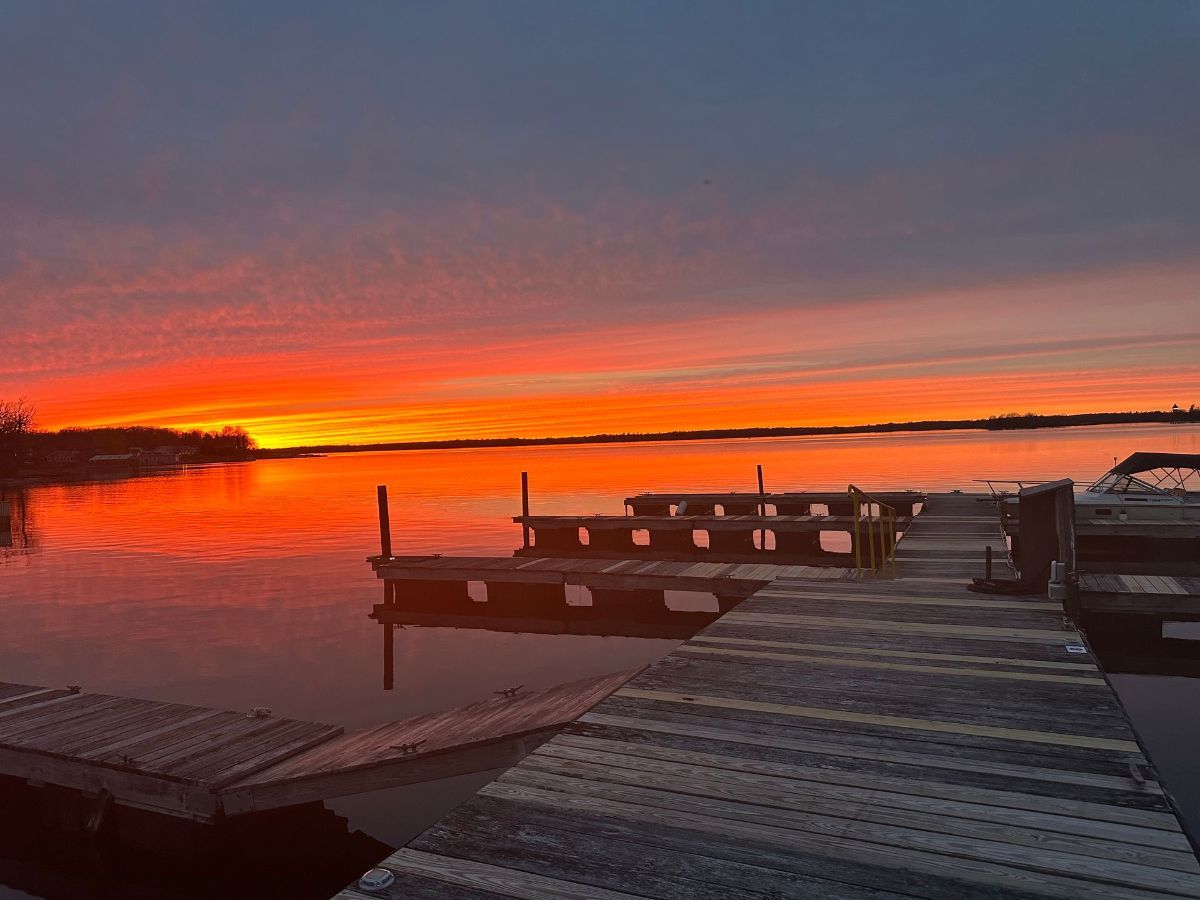 A white house with a green roof and a deck