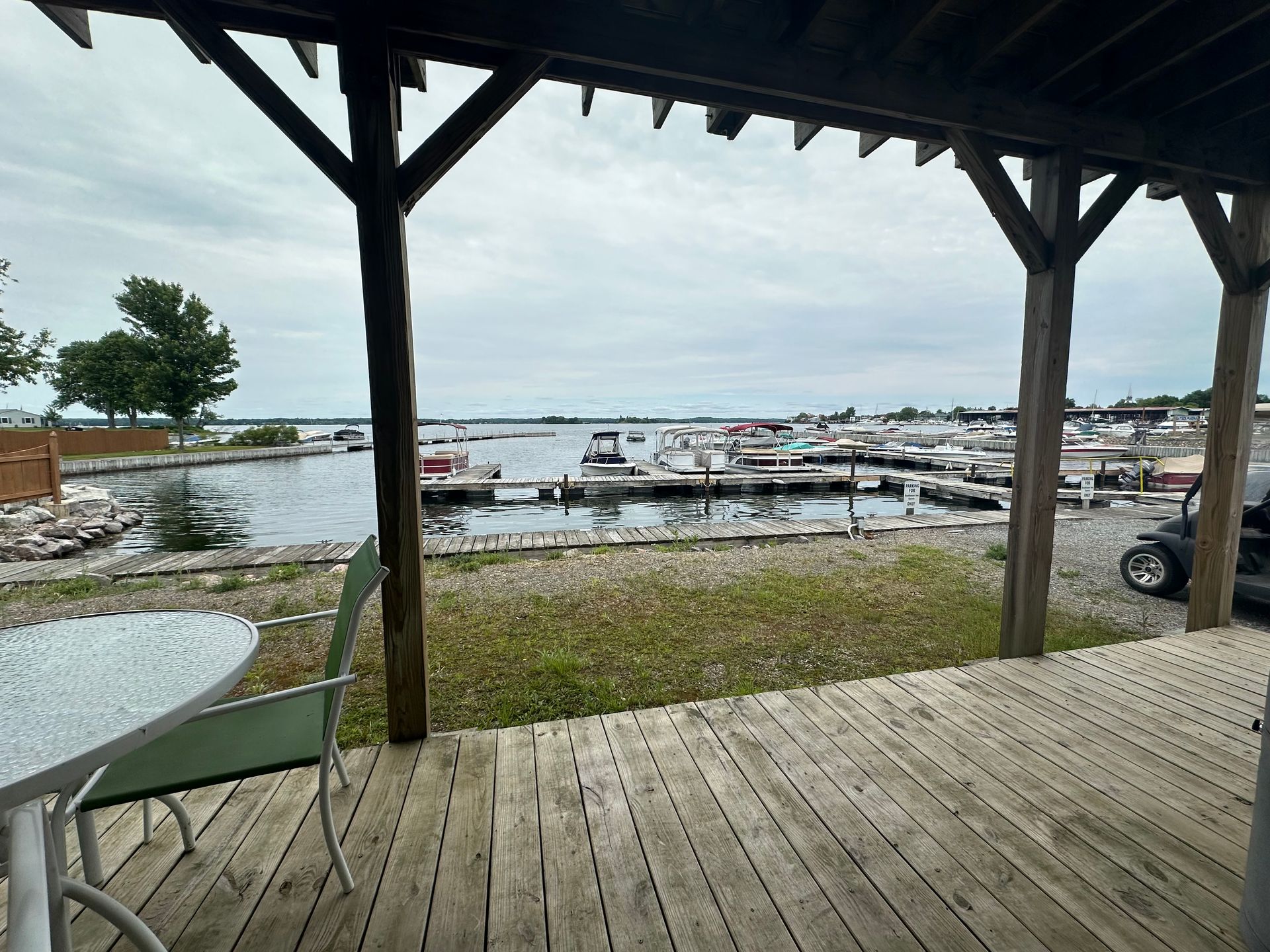 A wooden deck with a table and chairs overlooking a body of water.