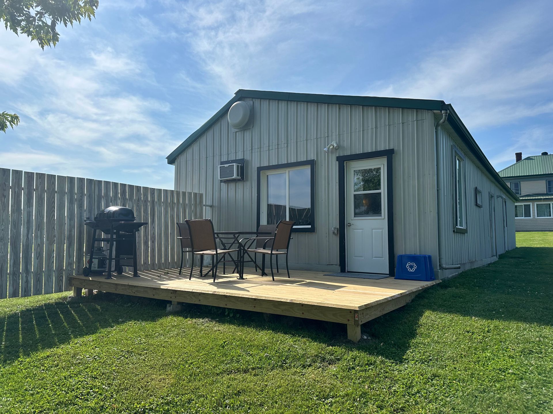 A small house with a table and chairs on the deck.