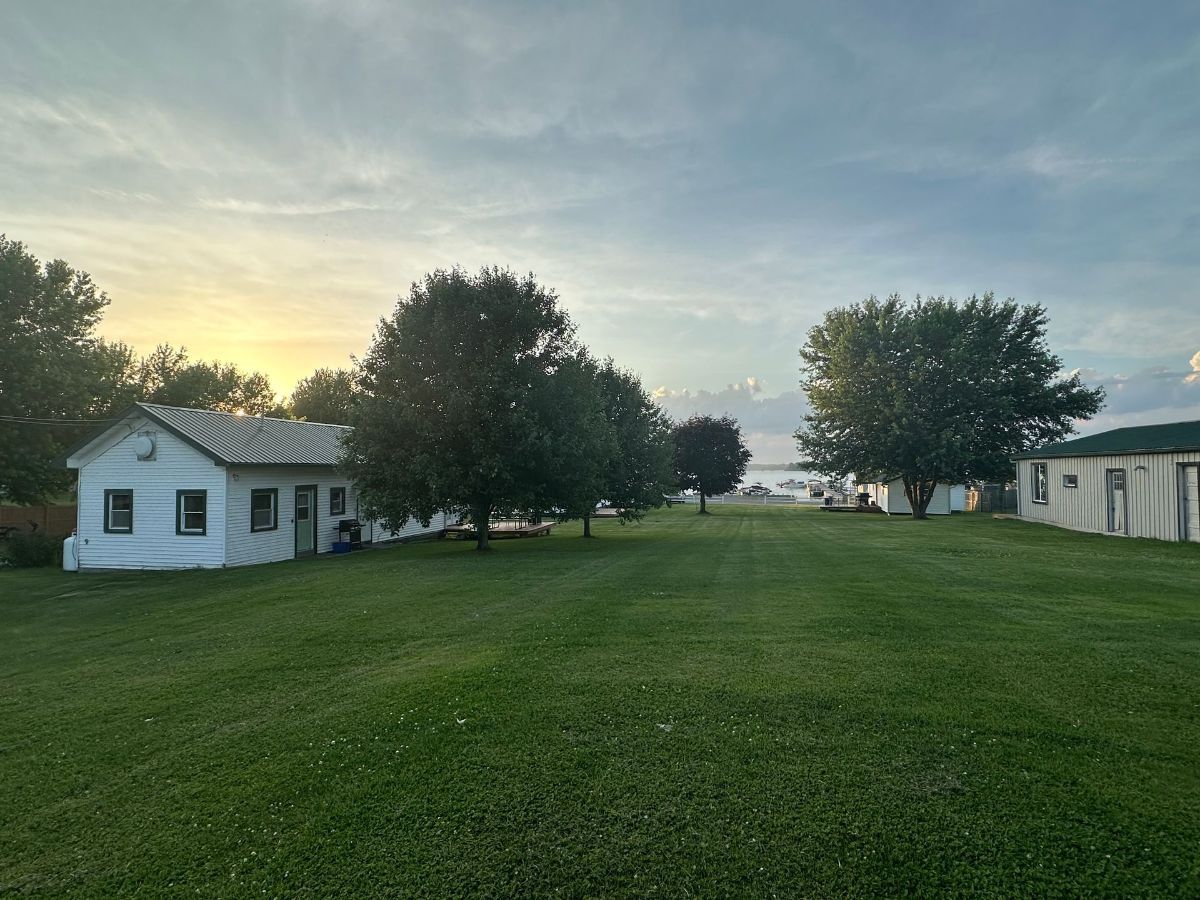 A kitchen with blue cabinets , a stove , a refrigerator , a table and chairs.