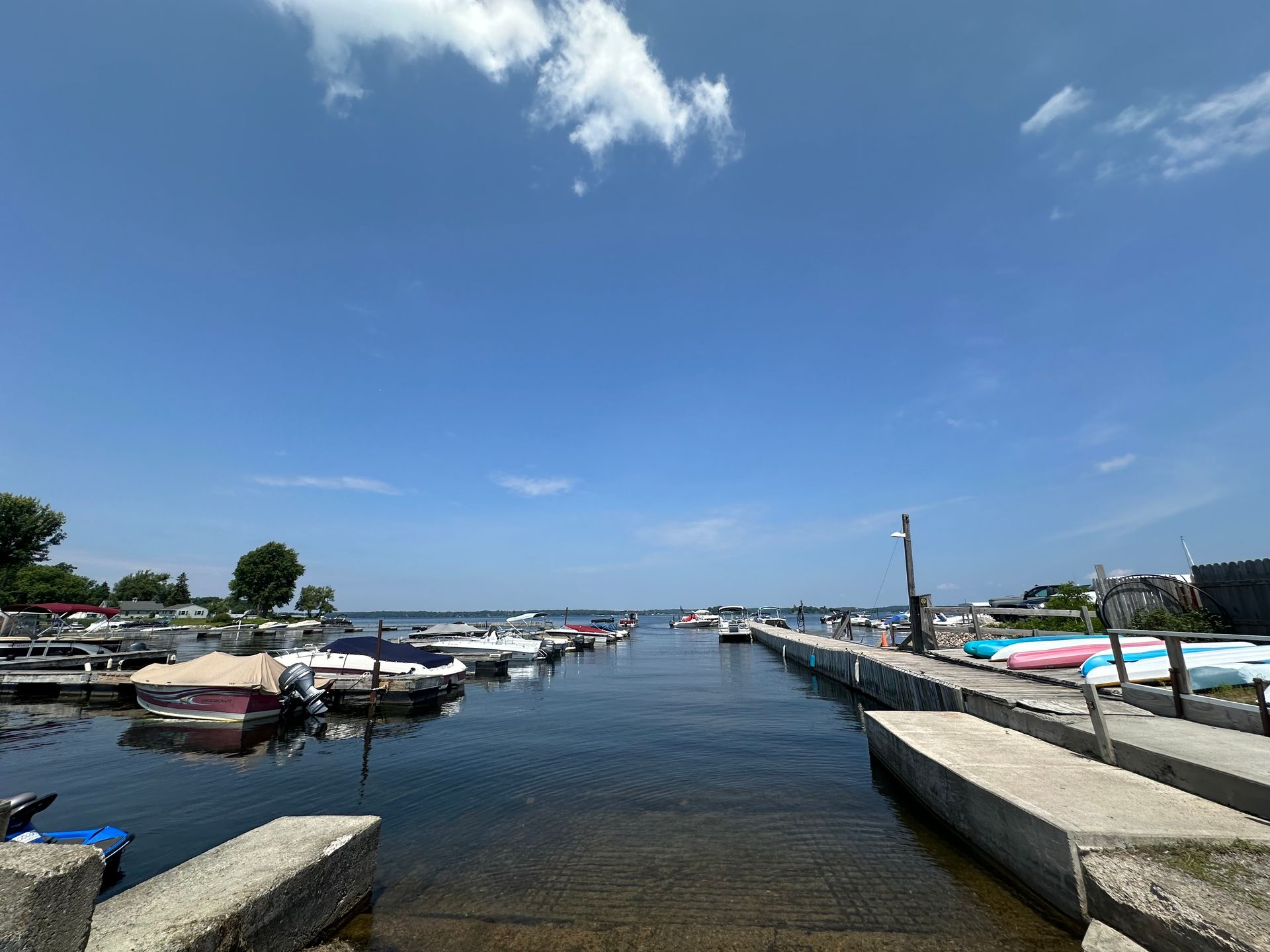 A house with a green roof sits in the middle of a lush green field.