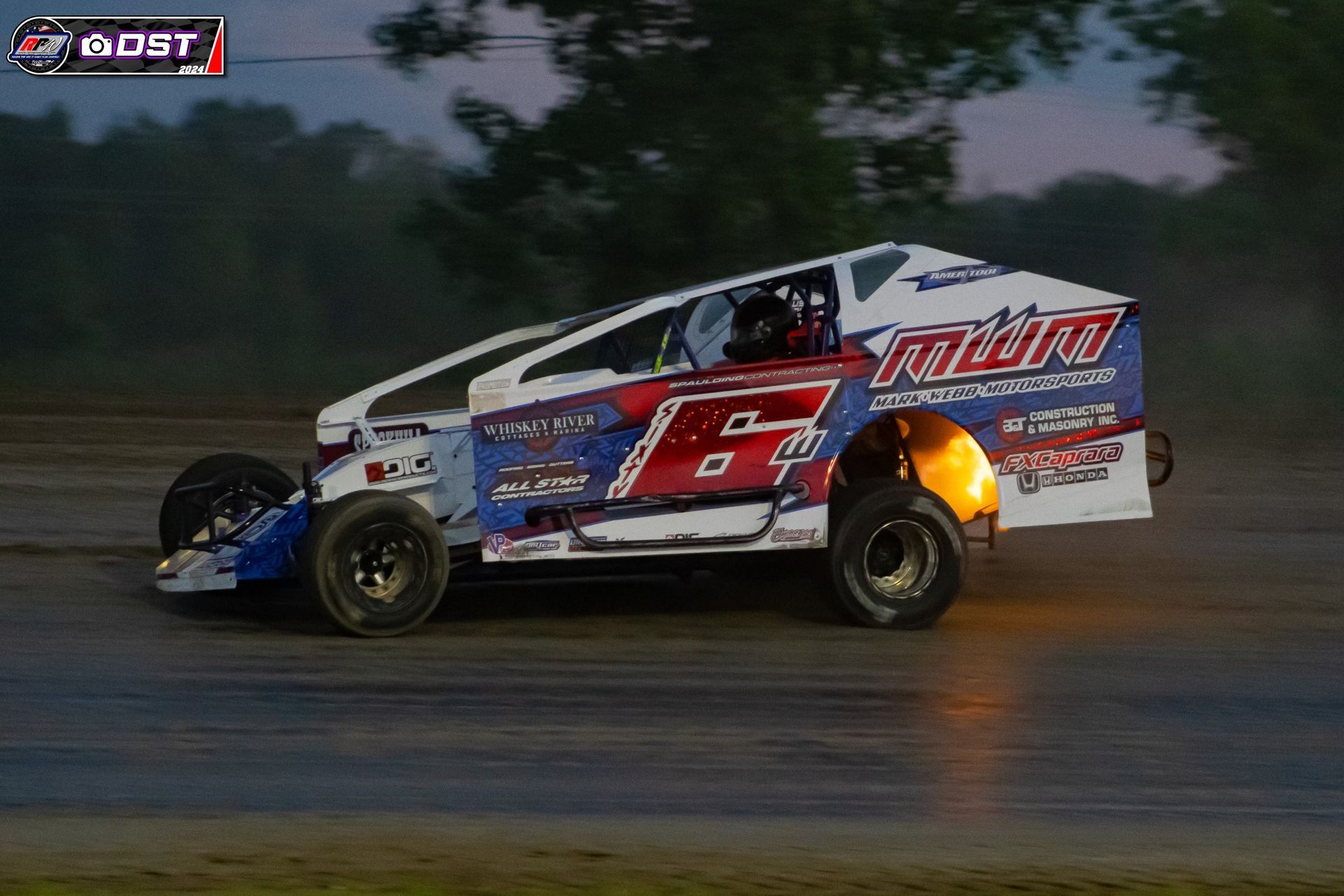 A race car is driving down a track at night.