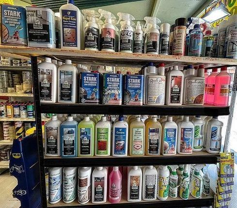 Uno scaffale pieno di prodotti per la pulizia, tra cui Stark