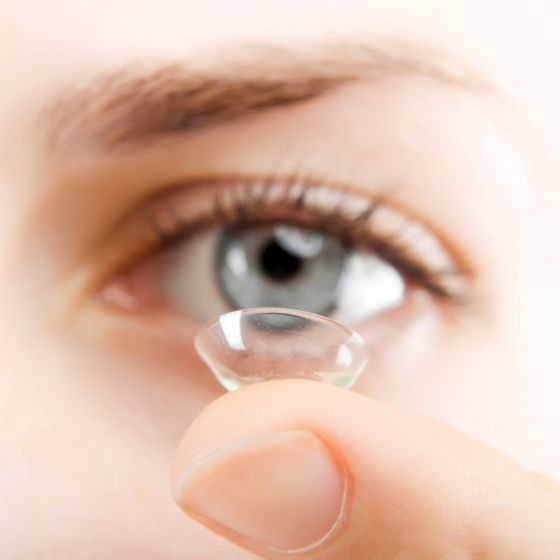 person with contact lens on fingetip
