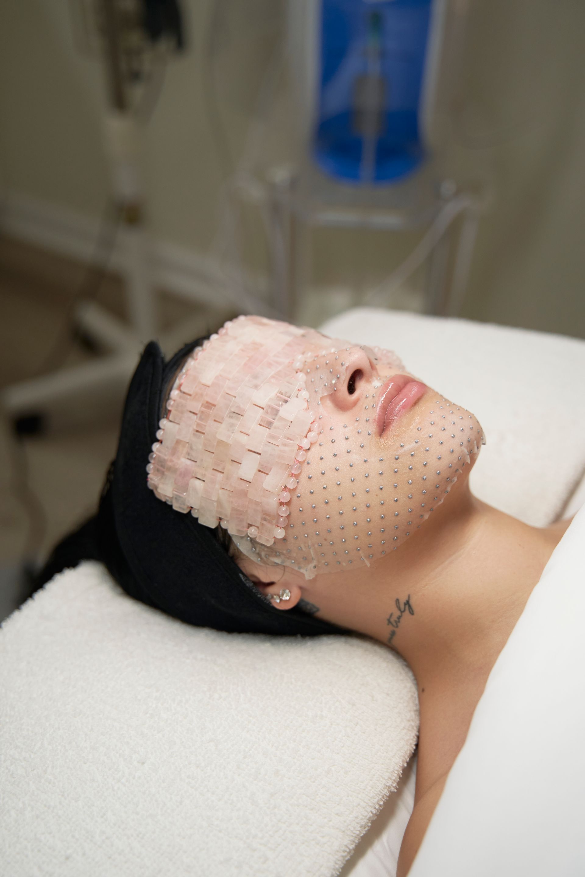 A woman is laying on a bed with a mask on her face.