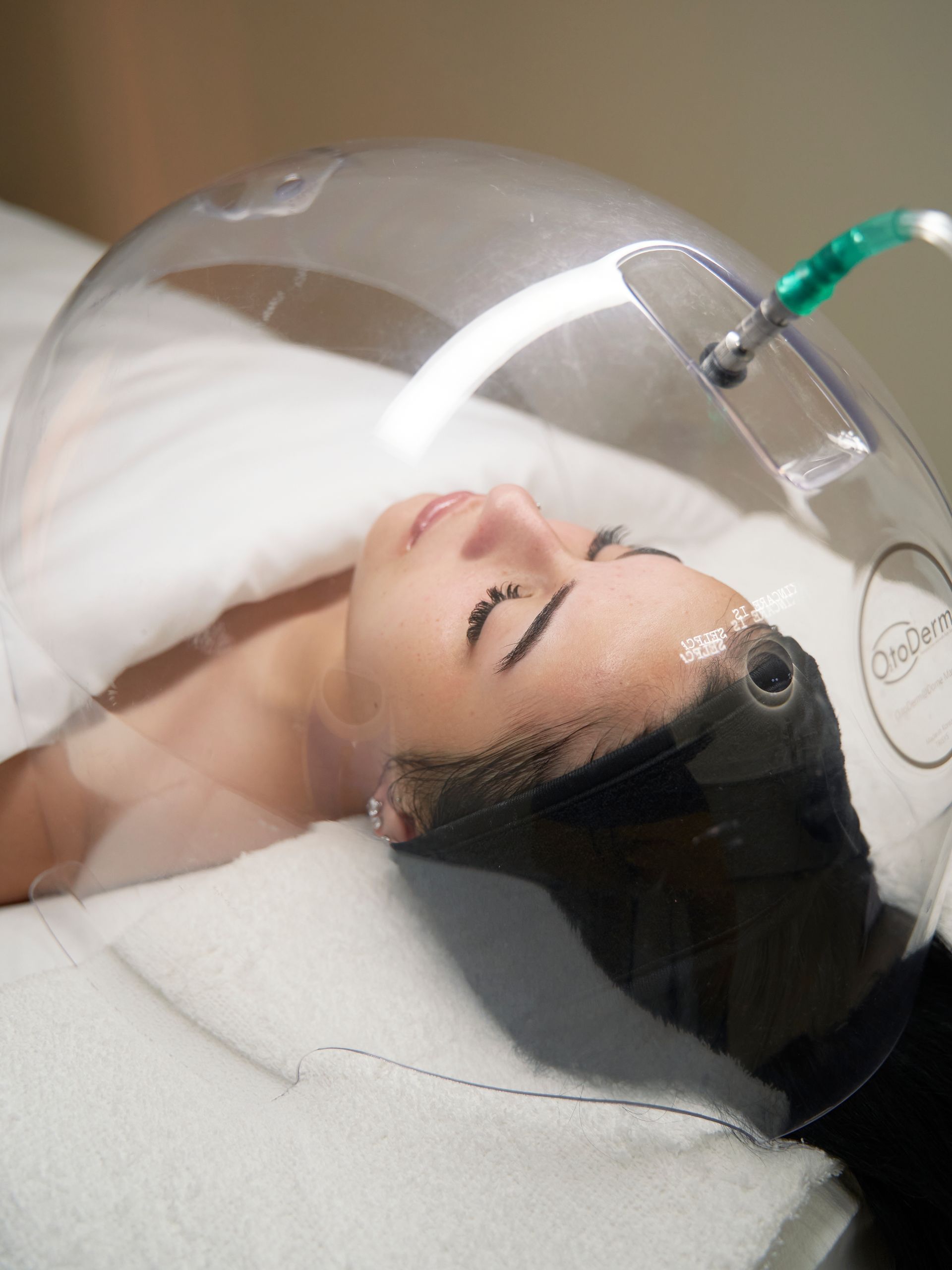 A woman is laying on a bed with a mask on her head.