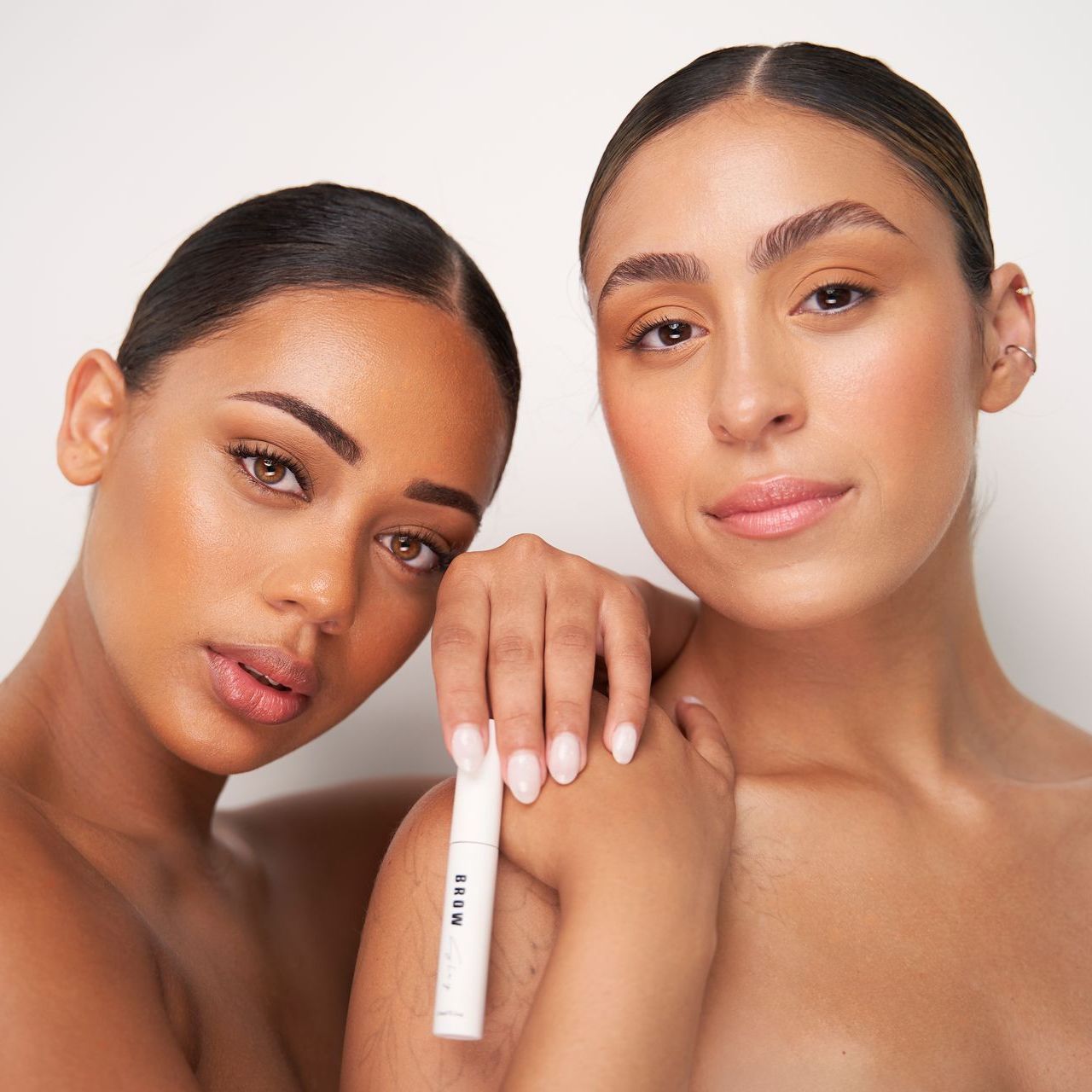 Two women standing next to each other with one holding a bottle of nivea