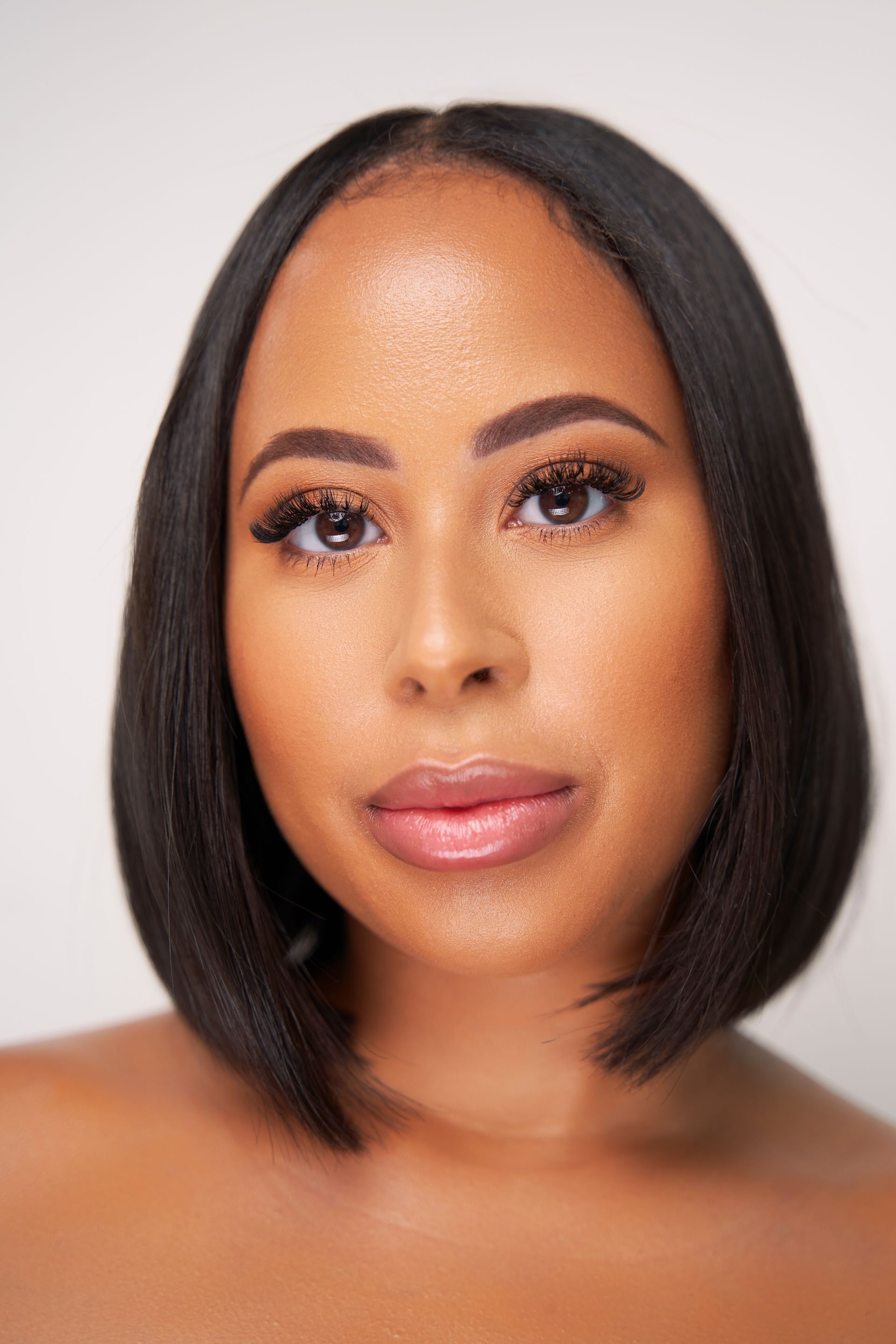 A close up of a woman 's face with a bob hairstyle.