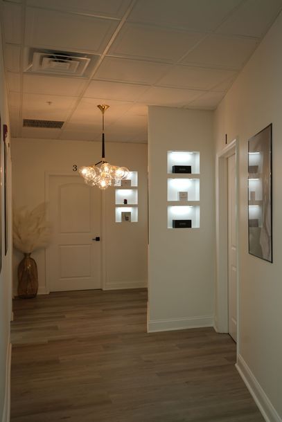 A hallway with wooden floors and white walls in a building.