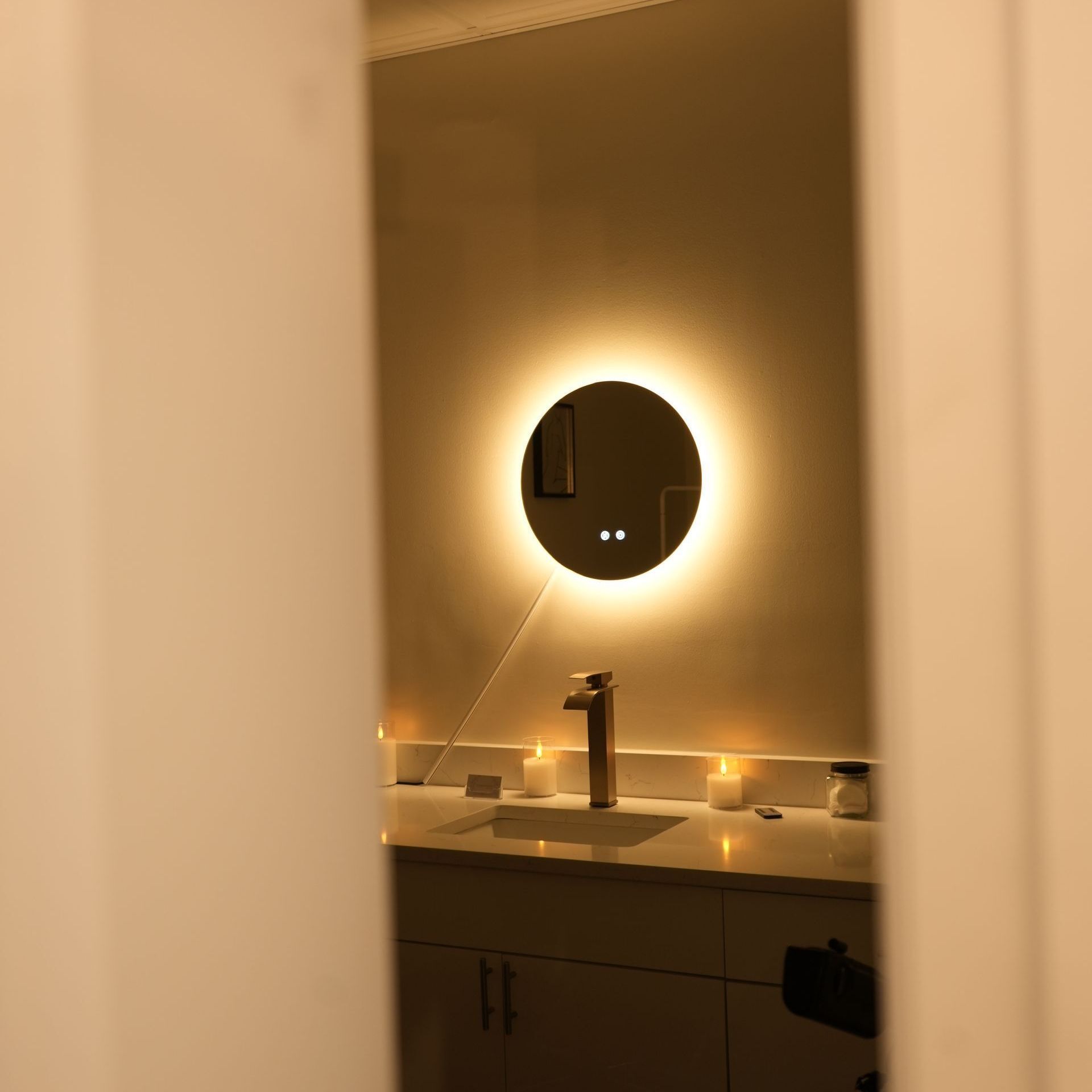 A bathroom with a round mirror and a sink