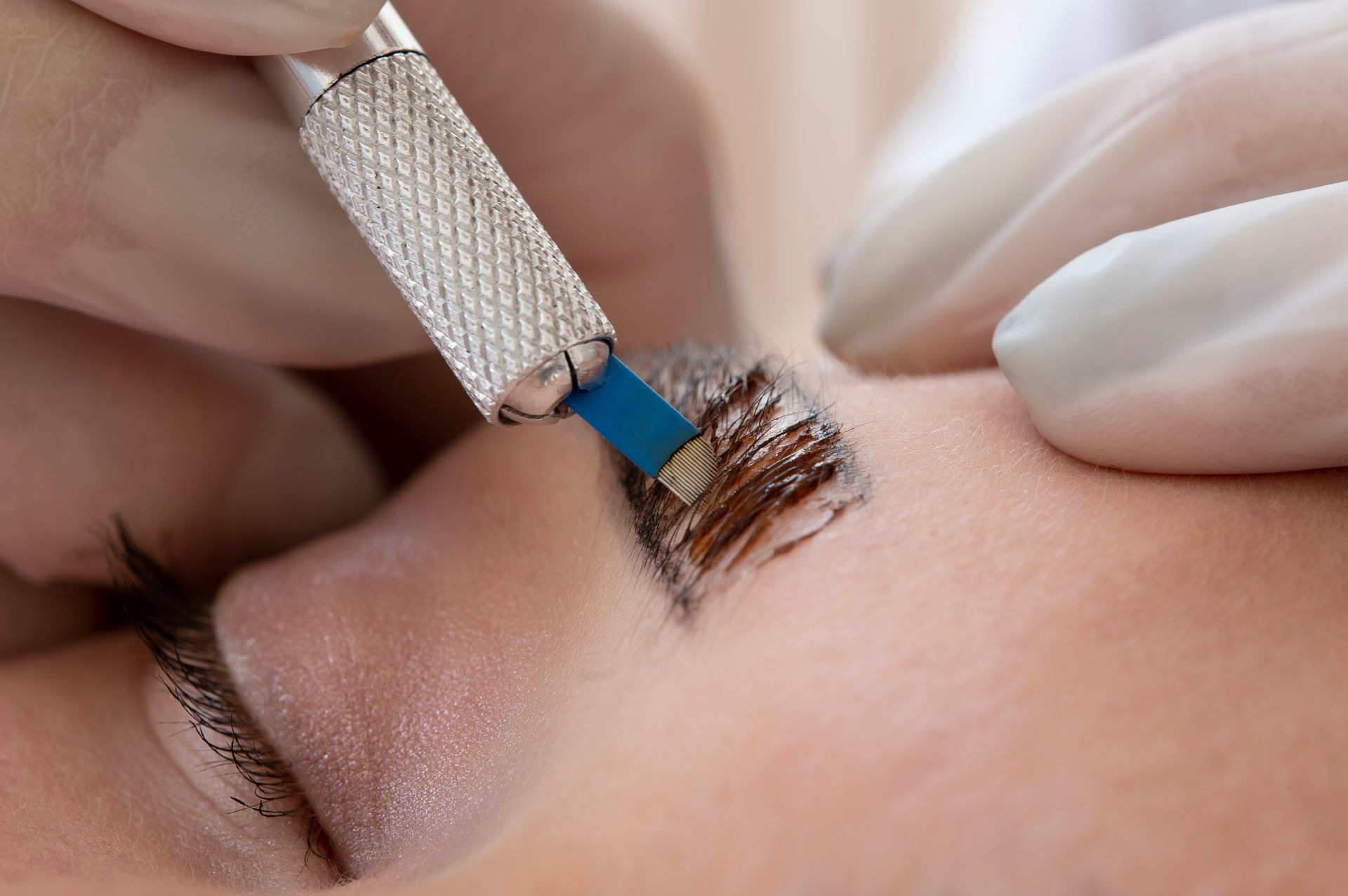 A woman is getting a microblading treatment on her eyebrows.