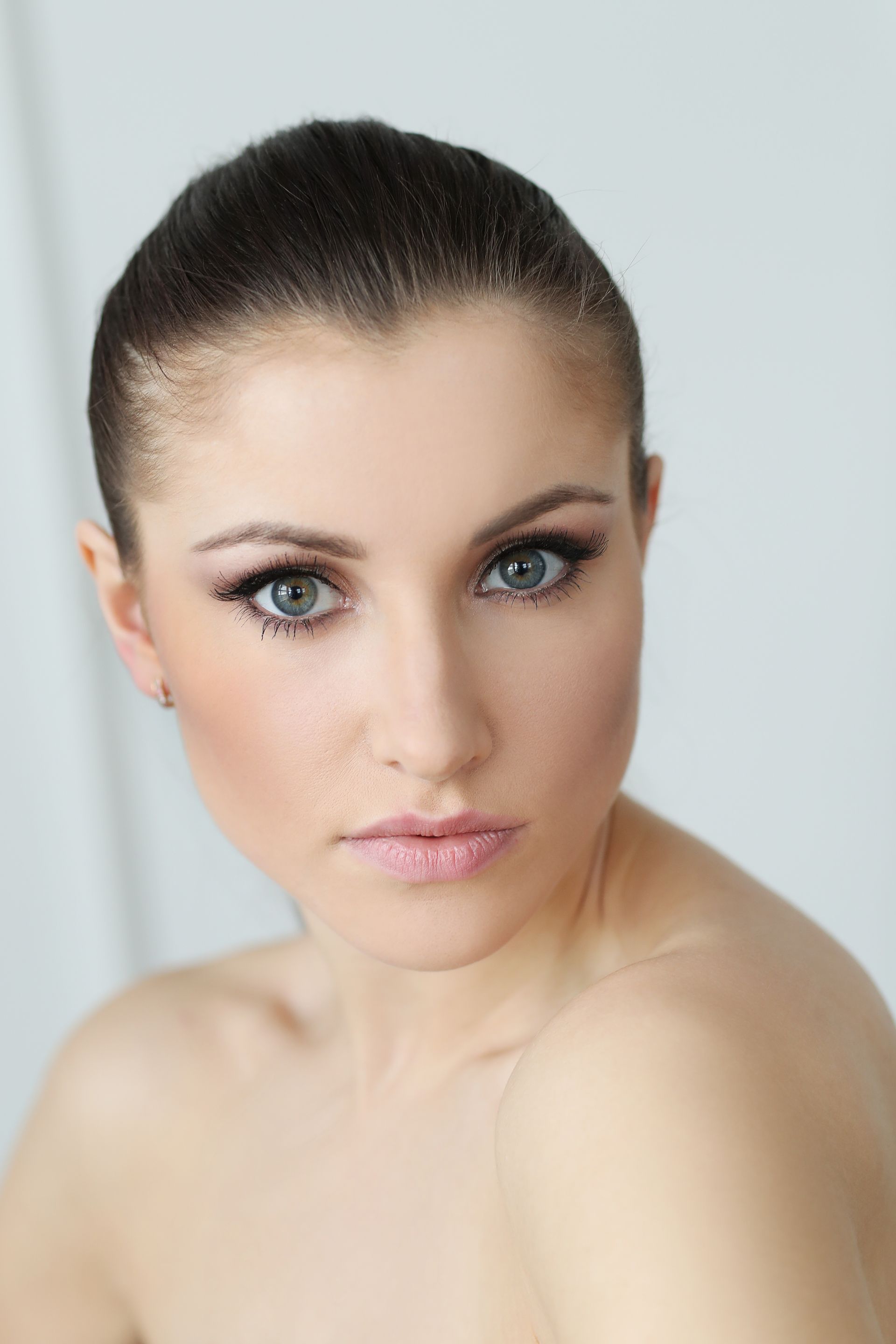 A close up of a woman 's face with a shaved head.