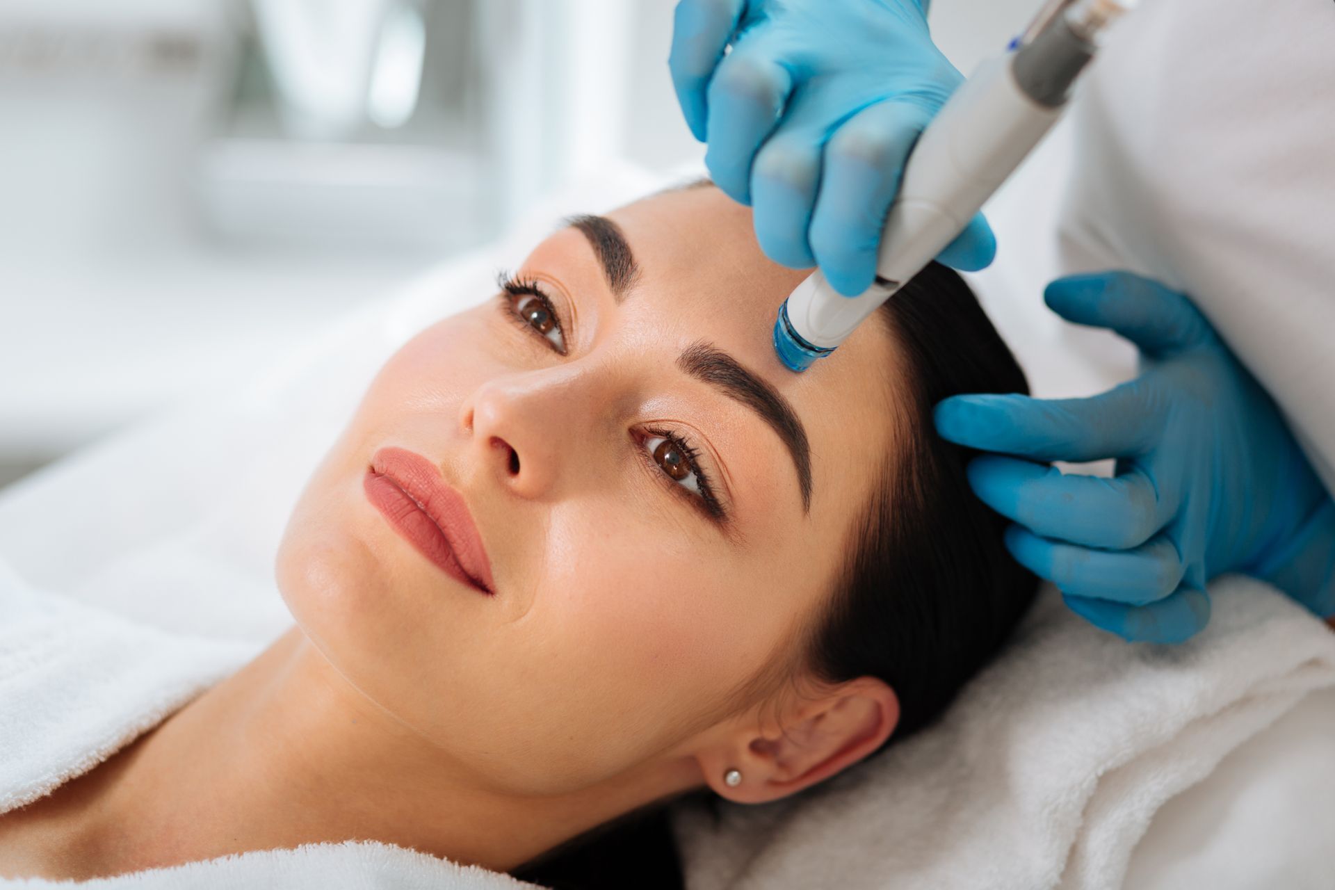 A woman is getting a facial treatment at a beauty salon.