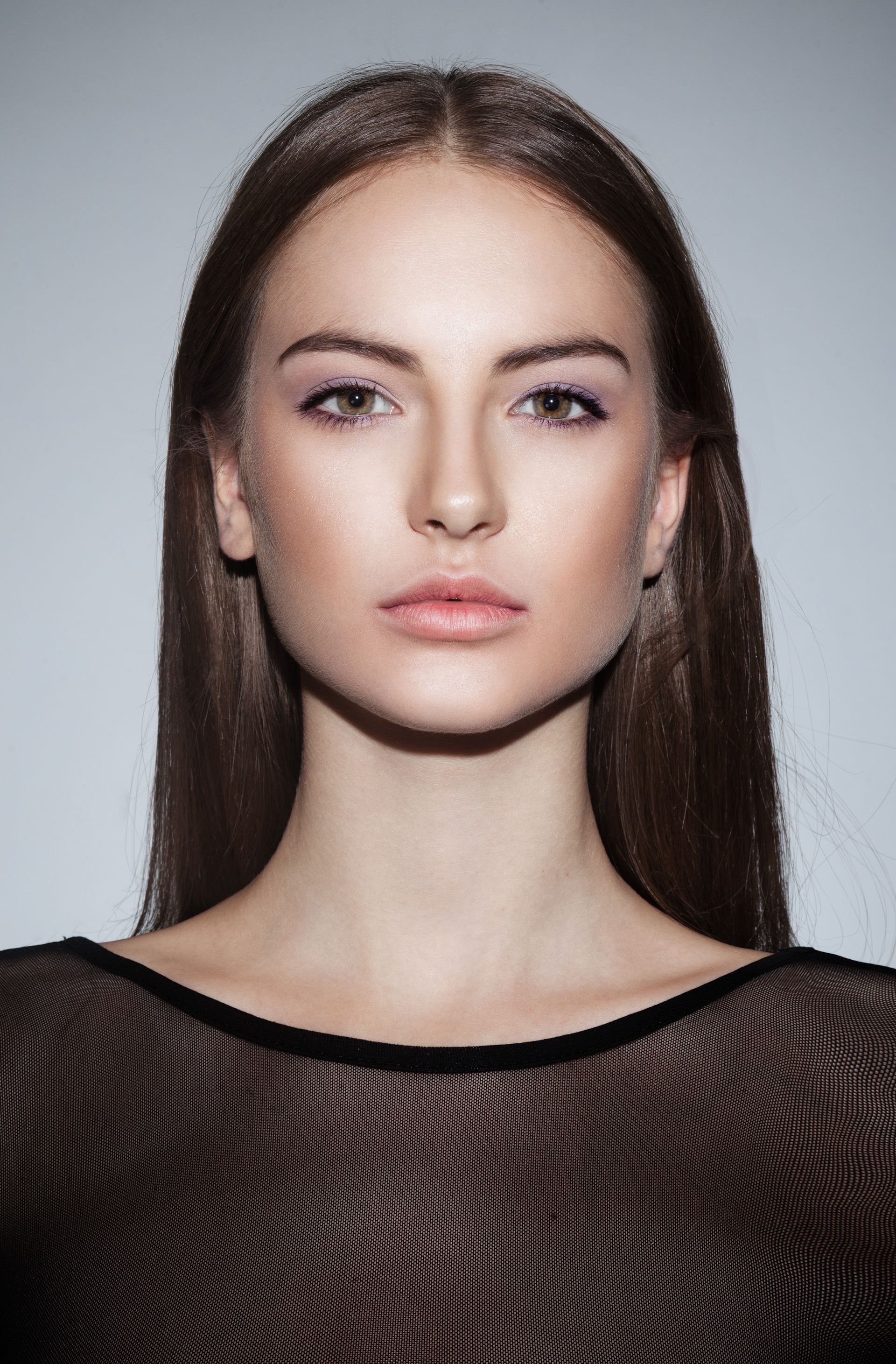 A woman with long hair is wearing a black top and looking at the camera.