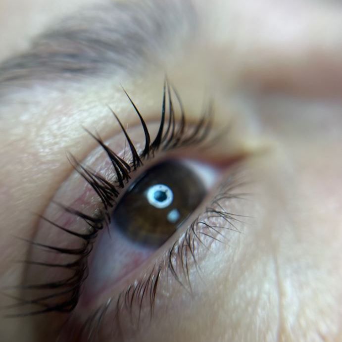 A close up of a woman 's eye with long eyelashes.