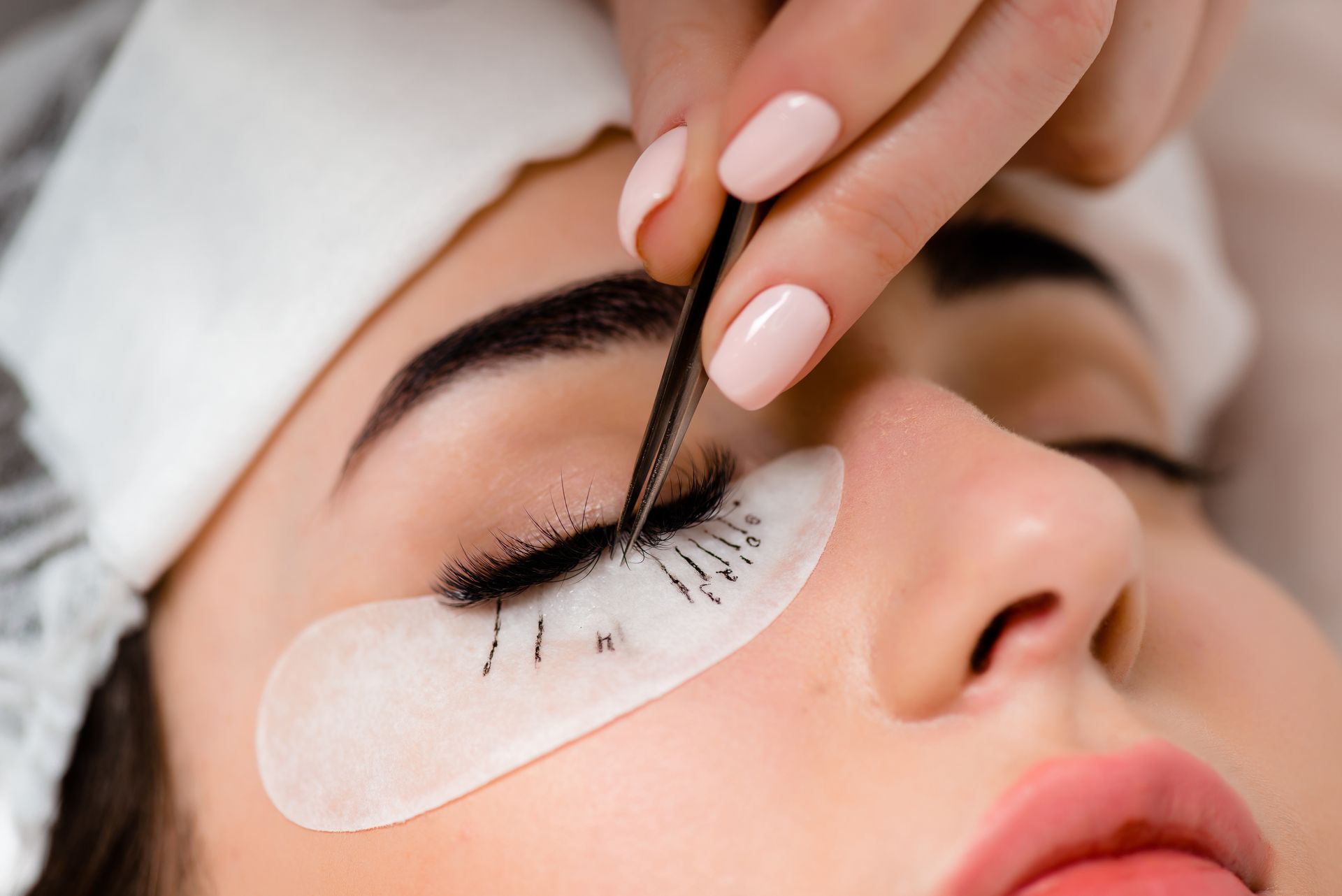 A woman is getting her eyelashes done at a beauty salon.