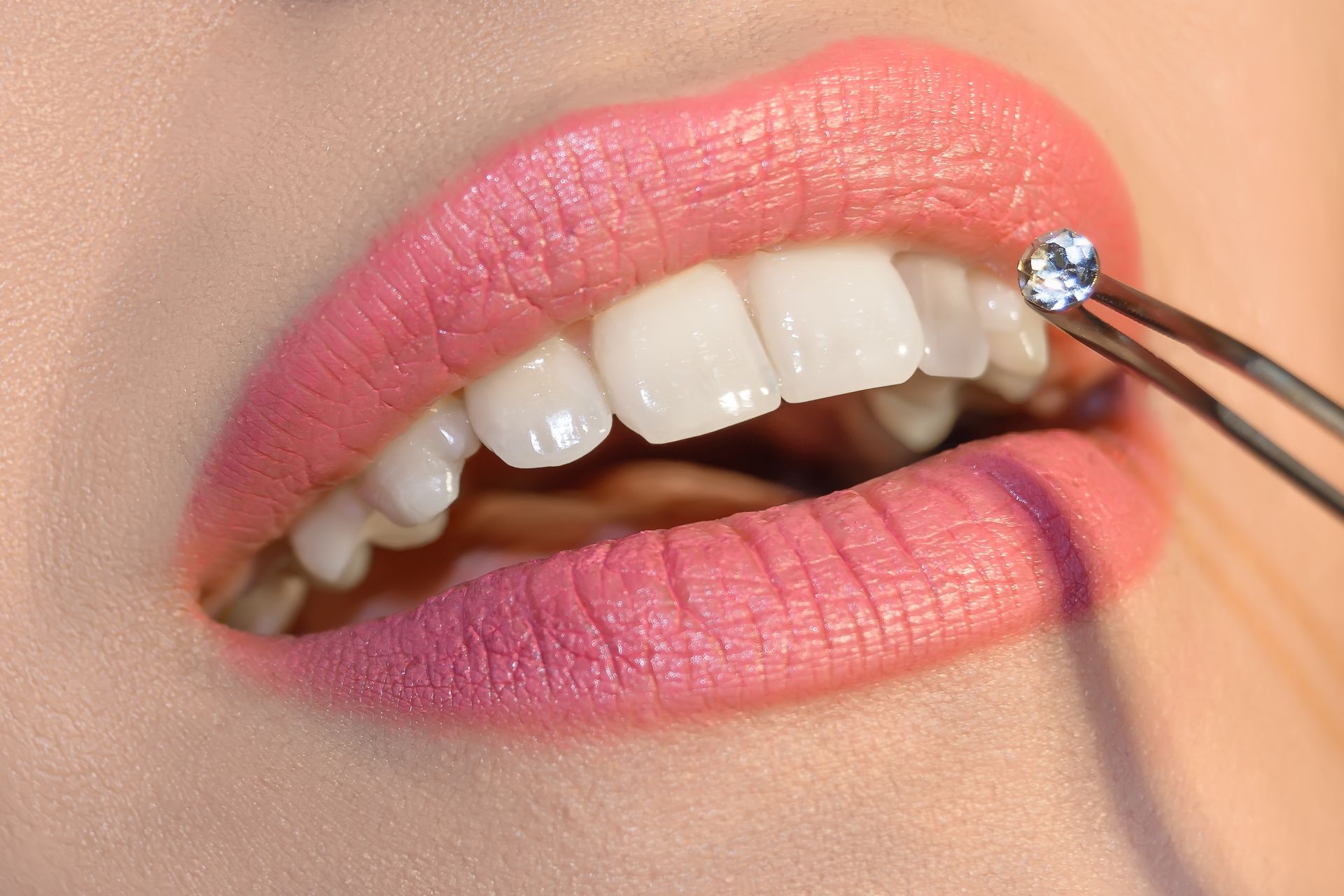 A close up of a woman 's mouth with a diamond in it.