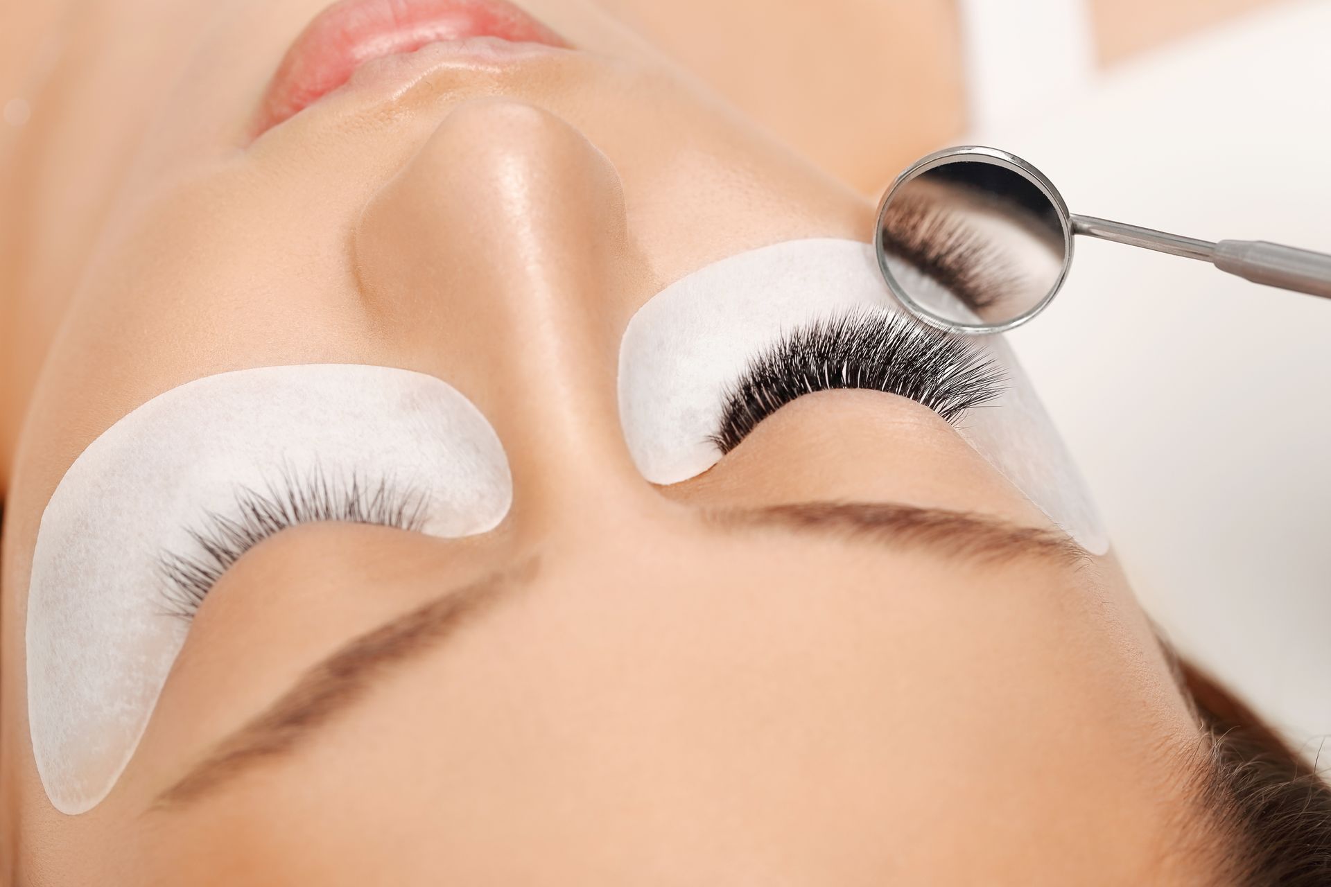 A woman is getting her eyelashes done at a beauty salon.