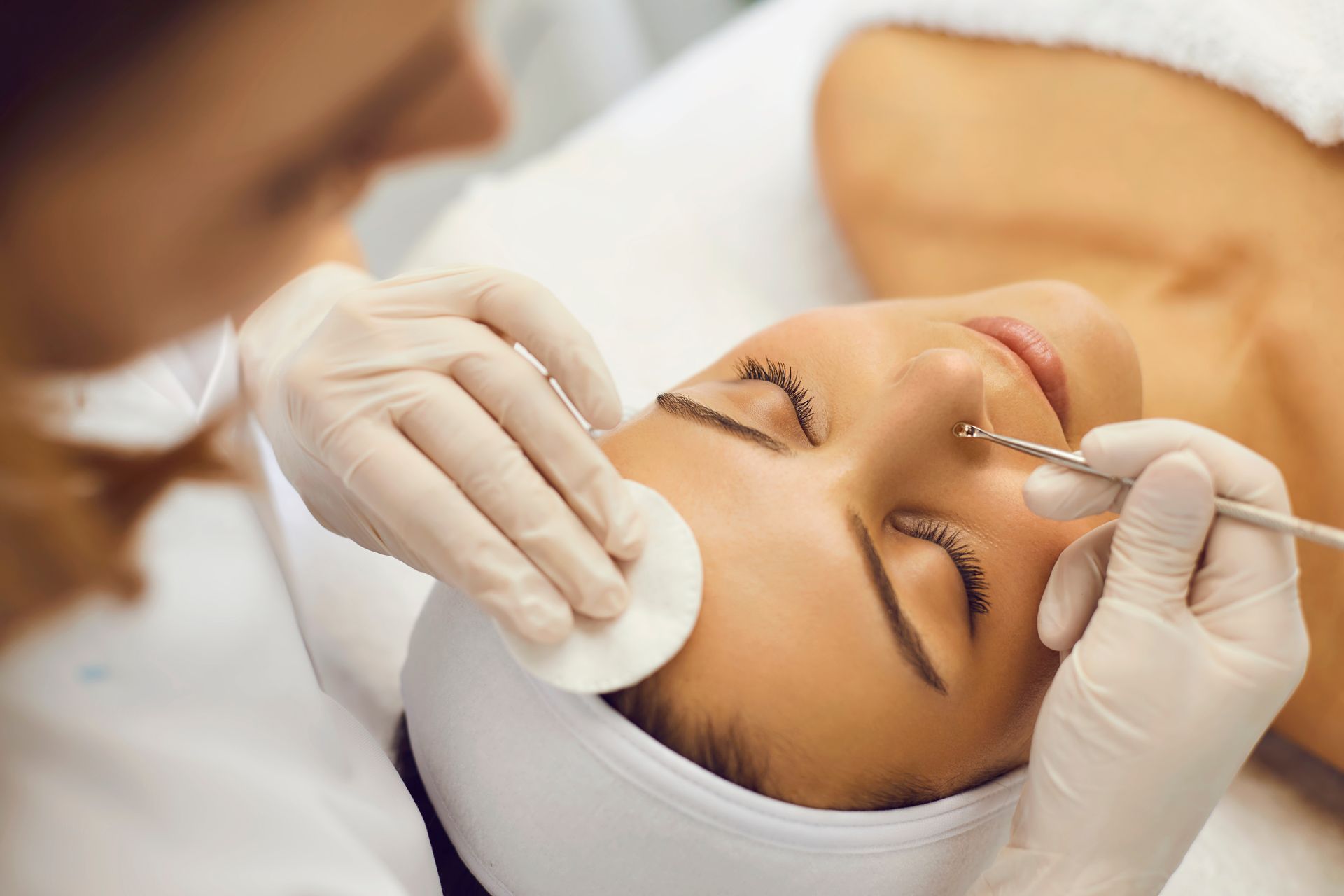 A woman is getting a facial massage at a spa.