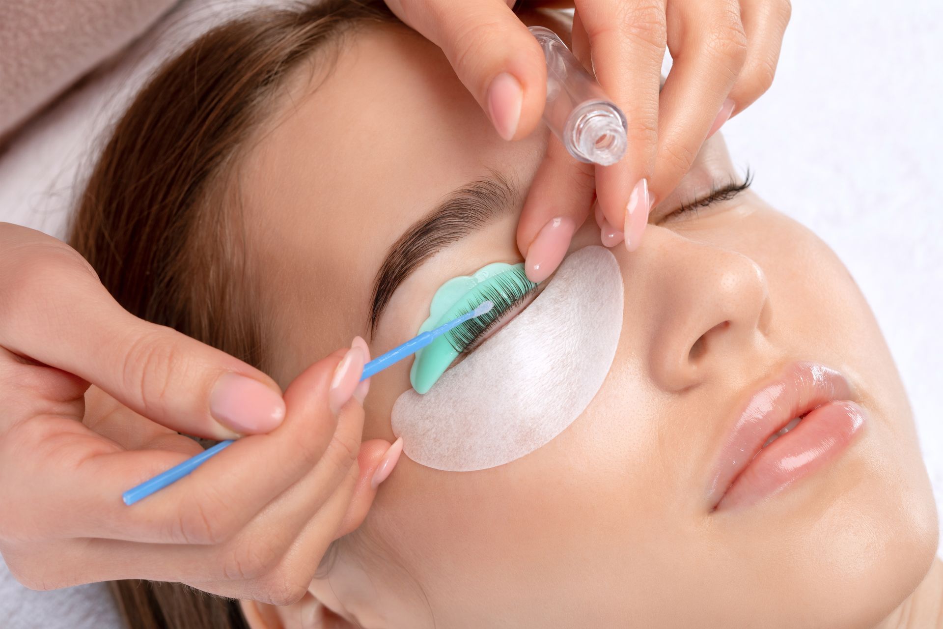 A woman is getting her eyelashes done at a beauty salon.