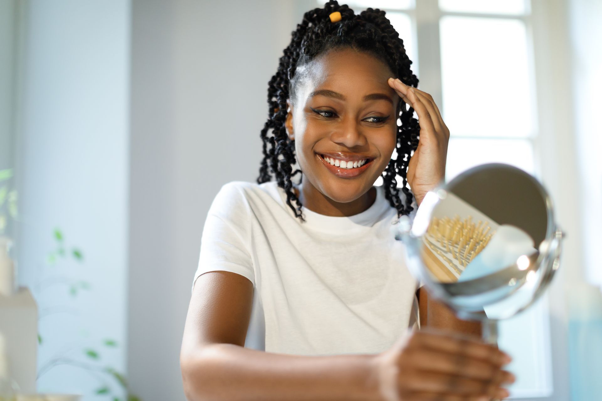 A woman is smiling while looking at herself in a mirror.