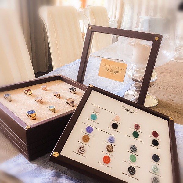 Vitrines met ringen en edelsteenmonsters op een tafel. Bruine houten lijsten, transparante panelen.